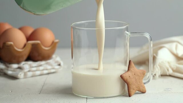 Christmas eggnog in glass cup with gingerbread cookies. Festive drink concept.