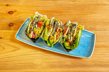 Tuna tacos with avocado and poppy seeds rolled with bud leaves
