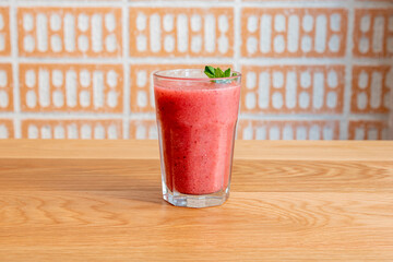 Forest berry juice with peppermint on wooden table