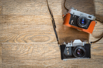 Retro photo cameras on wooden background. Flat lay view from above with space for copy