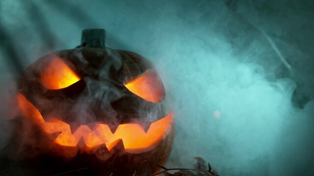 Scary Pumpkin Jack O Lantern with Flaring Candles. Halloween Background. Super Slow Motion Filmed on High Speed Cinema Camera at 1000 fps.
