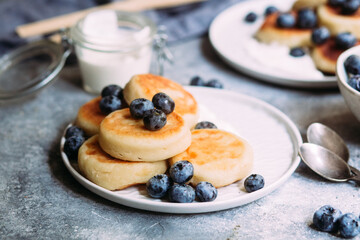cheesecakes with berries and sauce on a gray background