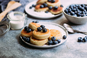 cheesecakes with berries and sauce on a gray background