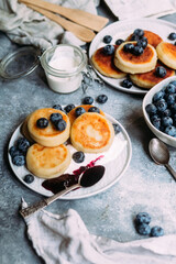 cheesecakes with berries and sauce on a gray background