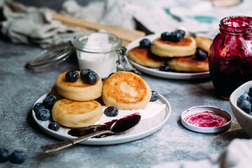 cheesecakes with berries and sauce on a gray background