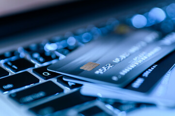 Close up shot of credit card on Laptop computer payment for purchases from online stores and online shopping. Concept of internet purchase. Blue colour tone and selective focus for background.