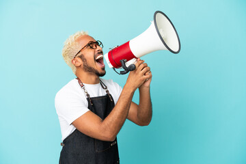 Restaurant Colombian waiter man isolated on blue background shouting through a megaphone