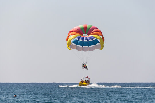 Turkey, Alanya, Side, 27.08.2021: Extreme entertainment, tourists on a parachute climb on a rope from a boat, ride a parachute on a rope over the sea