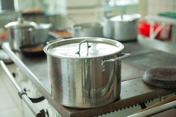 Large pot for cooking. Kitchen utensils in the dining room. Stainless steel water tank.