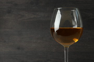 Glass of white wine on dark wooden background