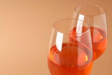 Glasses of wine on beige background, space for text