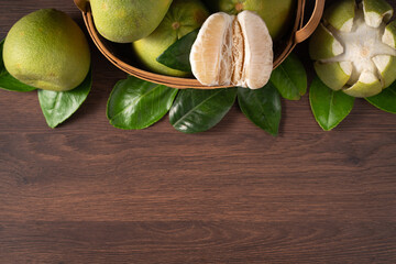 Fresh pomelo fruit on dark wooden table background.