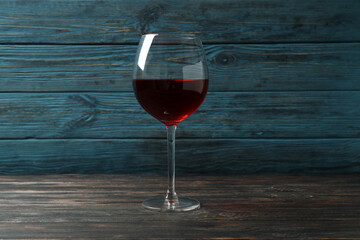 Glass of red wine on rustic wooden background