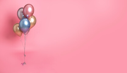 Helium inflated balloons on pink background