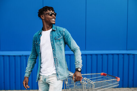 black afro guy shopping with a shopping cart, guy posing, fashion fashion, shopping near the mall