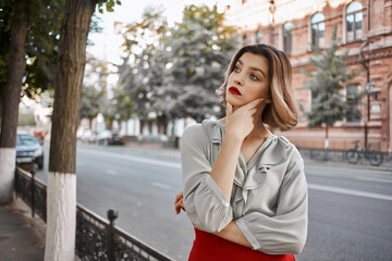 Fototapeta premium beautiful woman in a red skirt city walk fun leisure lifestyle