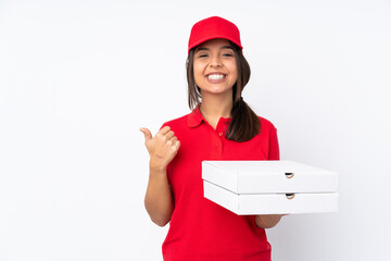 Young Pizza delivery girl over isolated white background pointing to the side to present a product