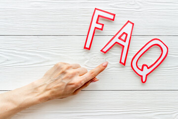Hands with faq - frequently asked questions - paper letters, top view