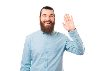 Bearded man is making hi gesture to greet someone over white background.