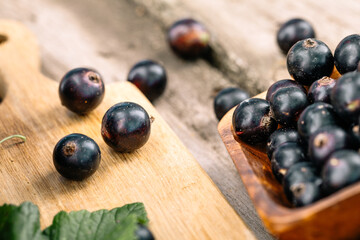 Fresh black currant. A handful of berries on a wooden table