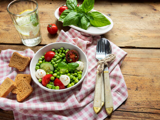 Salad vegetarian. Fresh vegetable salad with tomato, cucumber, basil, green peas, mozzarella cheese.