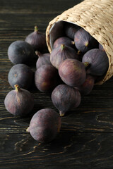 Wicker pot with fig on rustic wooden background