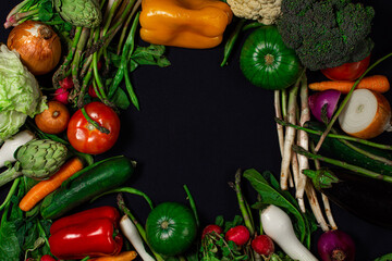 Verduras frescas variadas, fondo negro.