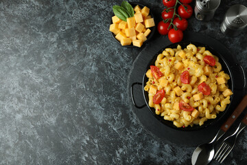 Concept of tasty eating with macaroni with cheese on black smokey table