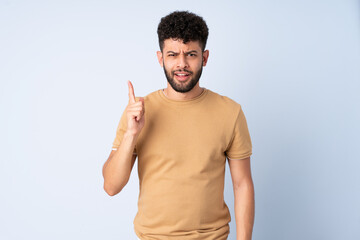 Fototapeta premium Young Moroccan man isolated on blue background intending to realizes the solution while lifting a finger up