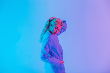 Female colored portrait of pretty stylish woman with fashionable clothes on multicolored neon and pink light indoors