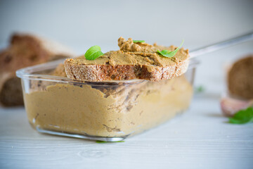 homemade liver pate with bread on a wooden table