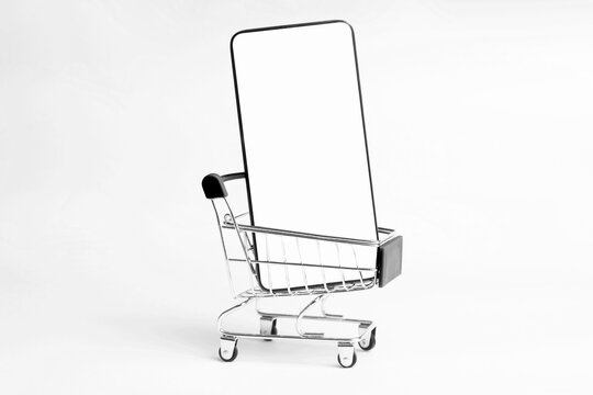 Shopping Cart And Mobile Phone Isolated On White