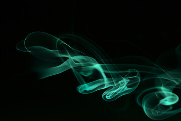 Abstract colored smoke moves on dark background. Wallpaper. Personal vaporizers fragrant steam. Concept of alternative non-nicotine smoking. E-cigarette. Texture. Design elements.