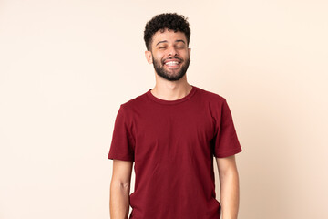 Obraz premium Young Moroccan man isolated on beige background laughing
