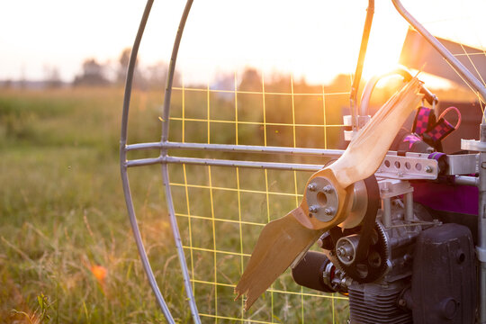 Broken wooden propeller of a gasoline-powered paraglider after a failed landing in the evening sun at sunset. Paragliding for individual paragliding flights. Extreme sports.