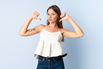 Young Lithuanian woman isolated on blue background proud and self-satisfied