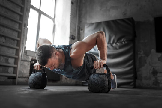 sport, bodybuilding, fitness and people concept - young man doing kettlebell push-ups in gym - Powered by Adobe