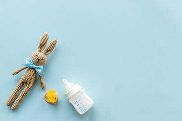 Child toy knitted rabbit with milk bottle, overhead view