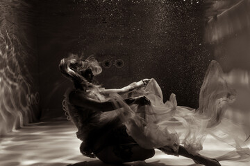 A girl with long hair swims underwater in a pink dress. She looks like an underwater dragon. Suitable for advertising