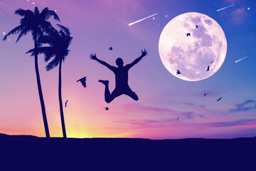 Man jumping and birds flying with palm tree at tropical sunset beach full moon abstract background. Freedom feel good and travel adventure concept.
