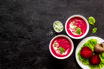Beet soup with sour cream and fresh beet roots. Top view