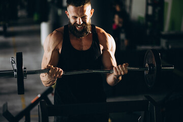 Obraz na płótnie Canvas Handsome man bodybuilder doing workout at gym