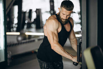 Handsome man bodybuilder doing workout at gym