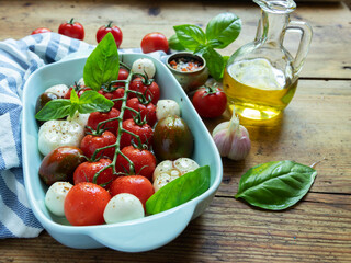 Fresh vegetable tomato, basil, mozzarella cheese for baking in the oven in ceramic dishes. cooking	