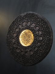 lamp on the wall with a curly round black frame and a yellow middle, classic interior style