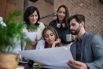 Young and old businesspeople sitting and working at desk in office, cooperation concept.