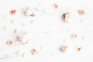 Flowers composition. White and pink flowers on marble background. Flat lay, top view