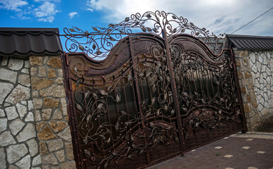 forged metal gates. Steel structures. Facade of a country house.