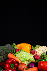 Verduras frescas variadas, fondo negro.