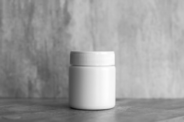 empty cosmetic plastic white cream jar. Gray background. container for cosmetics. Cosmetic concept. minimalistic photo.